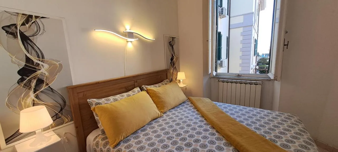 Il letto matrimoniale in legno della Dimora del Sole con le lampade accese